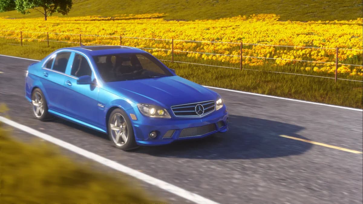 A blue car travels along a road bordered by a bright yellow field