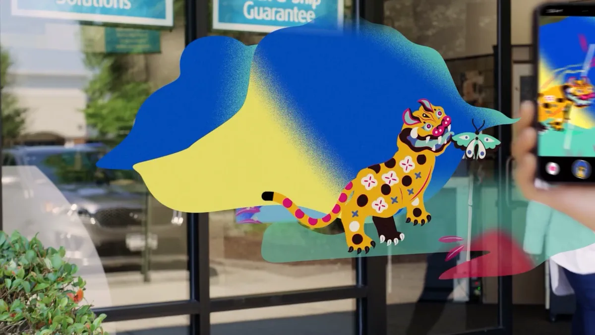 A colorful spotted gecko appears beside a phone in an augmented-reality scene